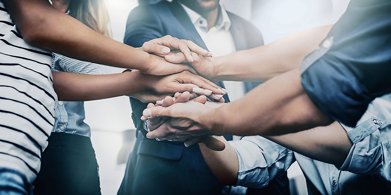 team of people stacking hands in agreement