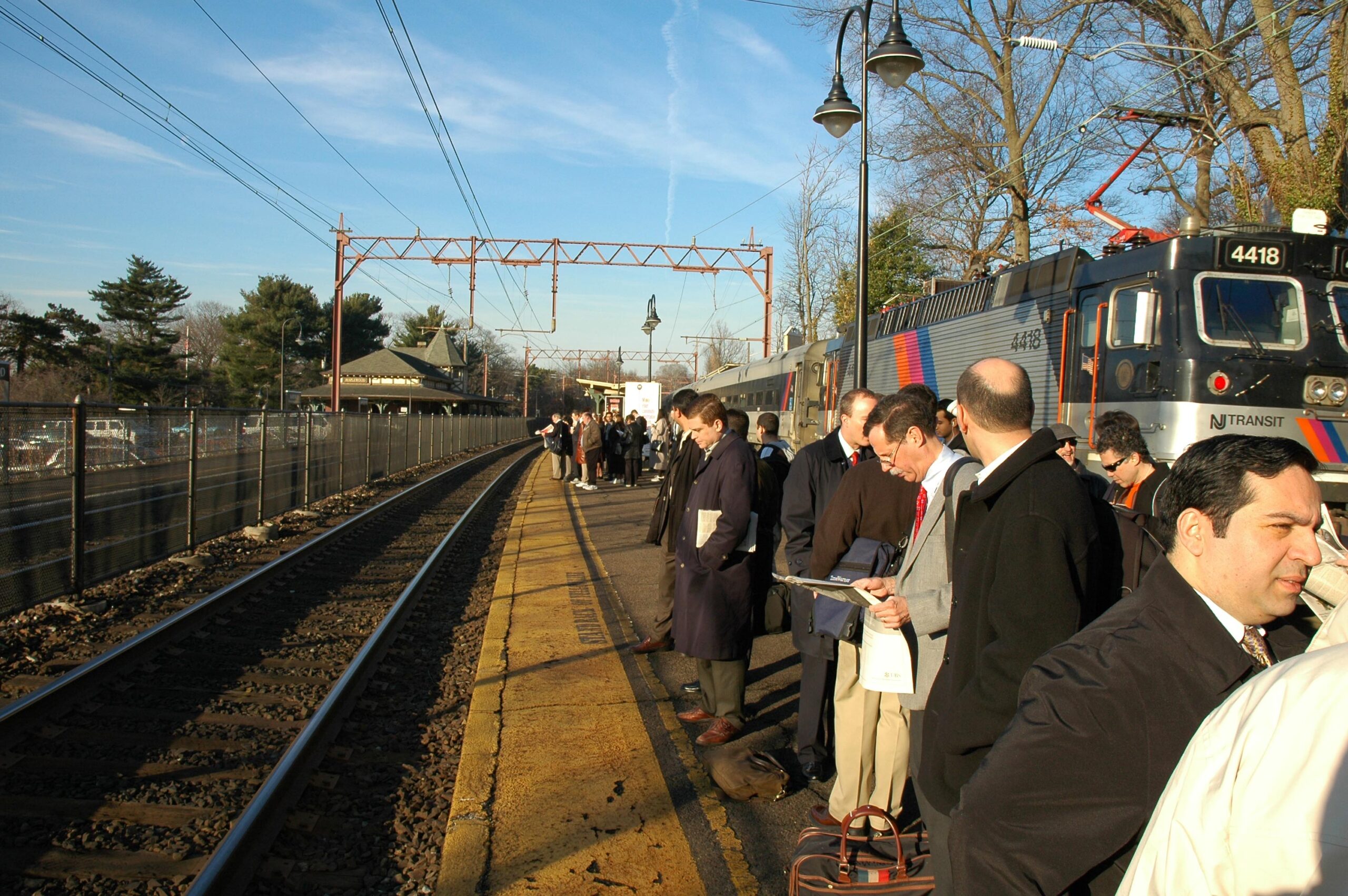 morning commuters wait for a train to arrive