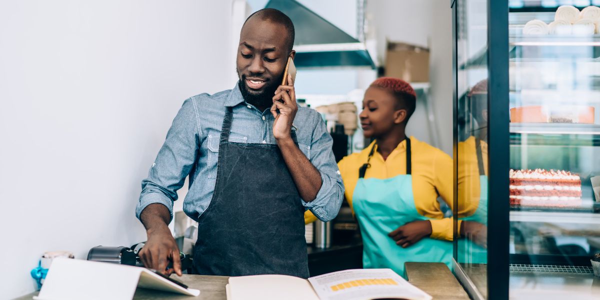 two business owners wearing aprons and working behind a counter