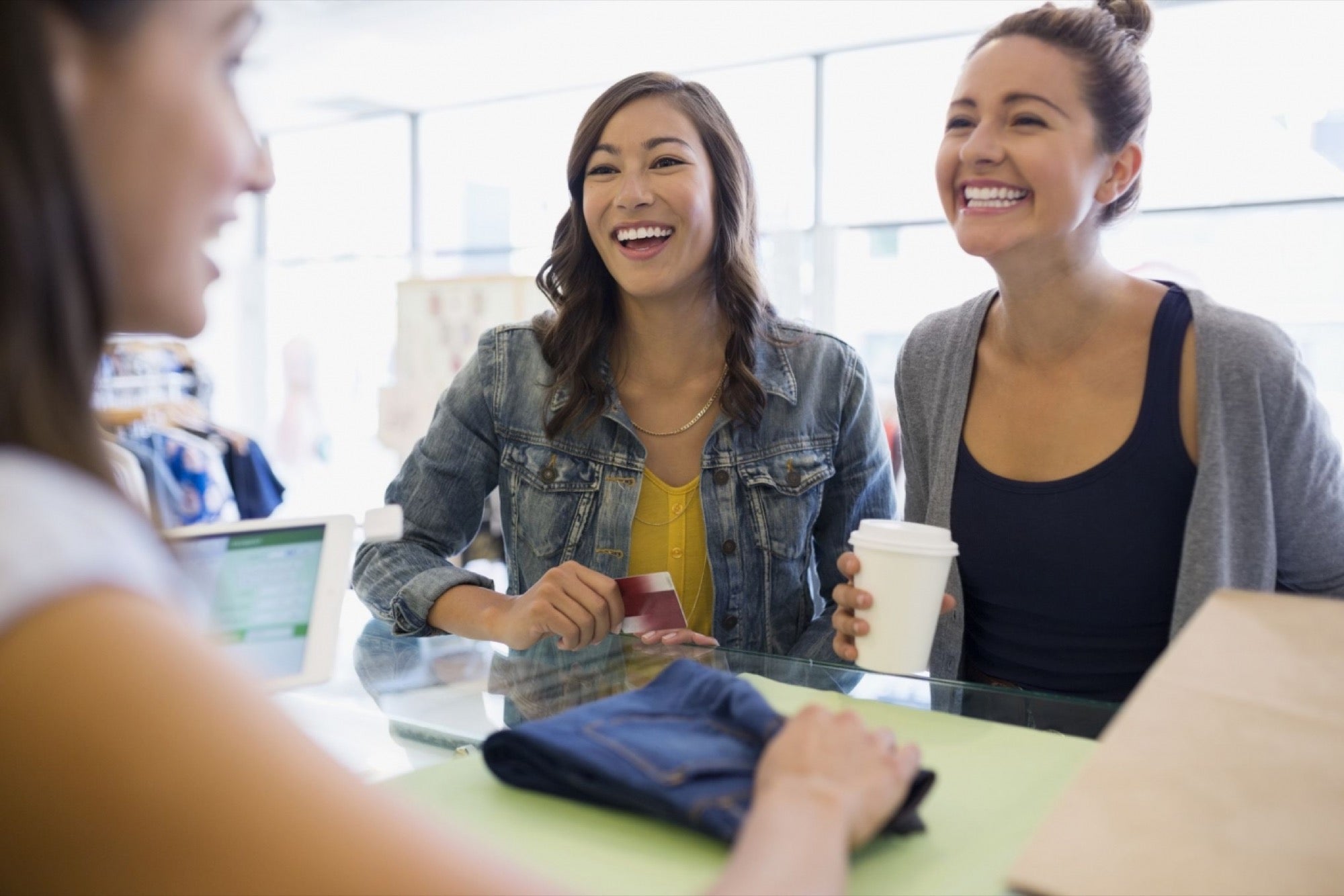 a business owner helps two smiling customers with a transaction