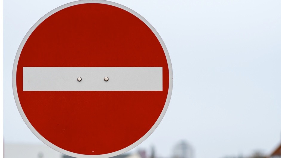 a round red warning sign with a white horizontal line through the center