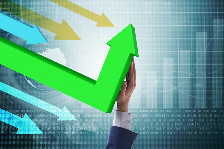 photo illustration showing a hand redirecting an arrow from up to down against a background of financial graphs