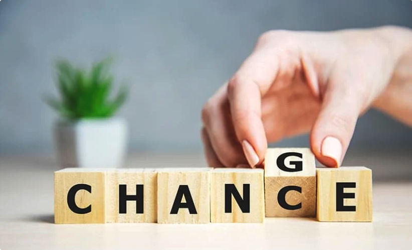 a hand changes one letter in a word made up of block letter, so that it now says "change" instead of "chance"