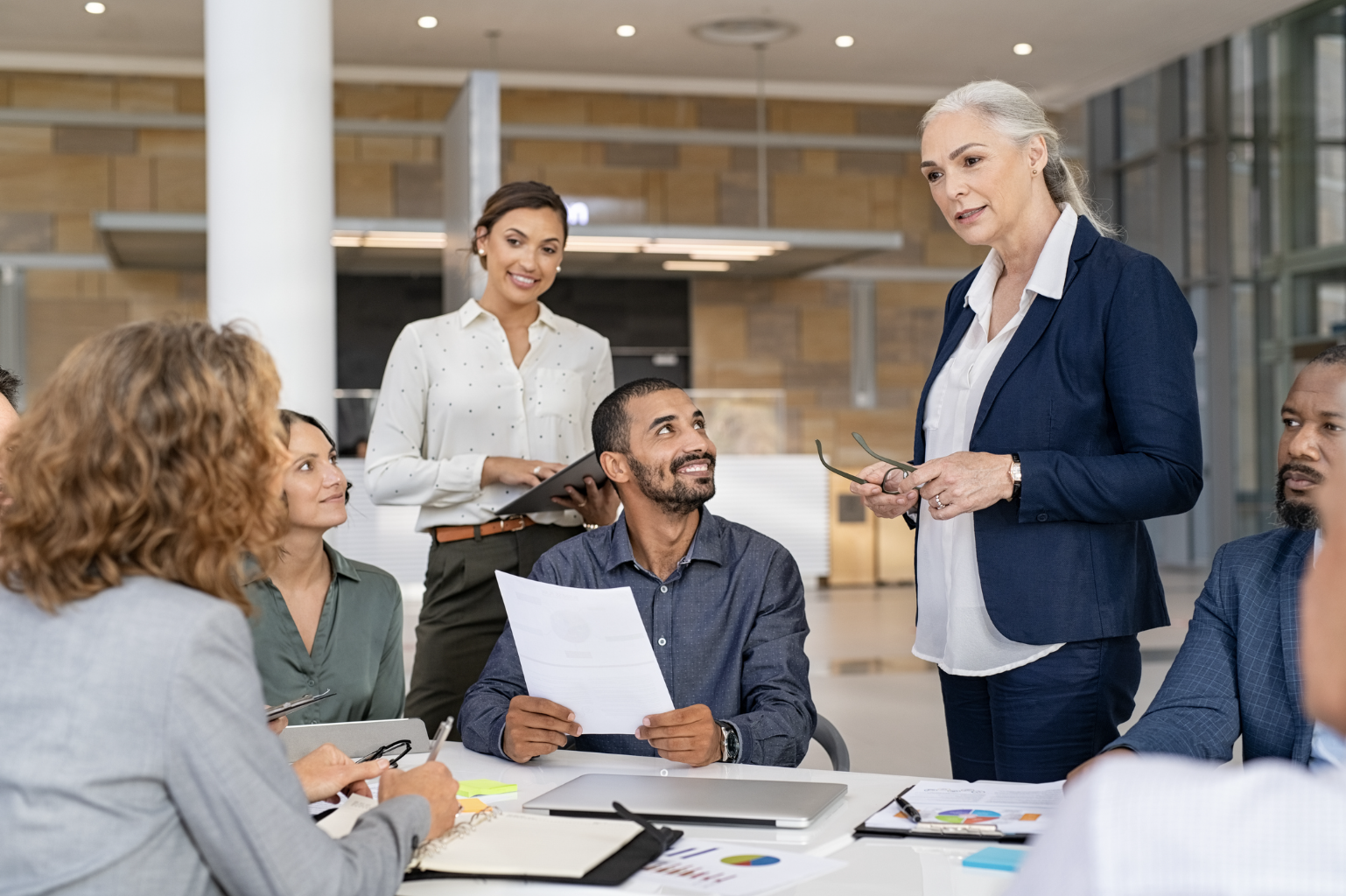 a corporate executive leads a meeting of a productive and happy team