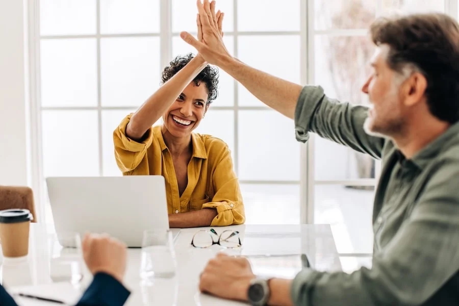 a business owner and employee celebrate success with a high-five